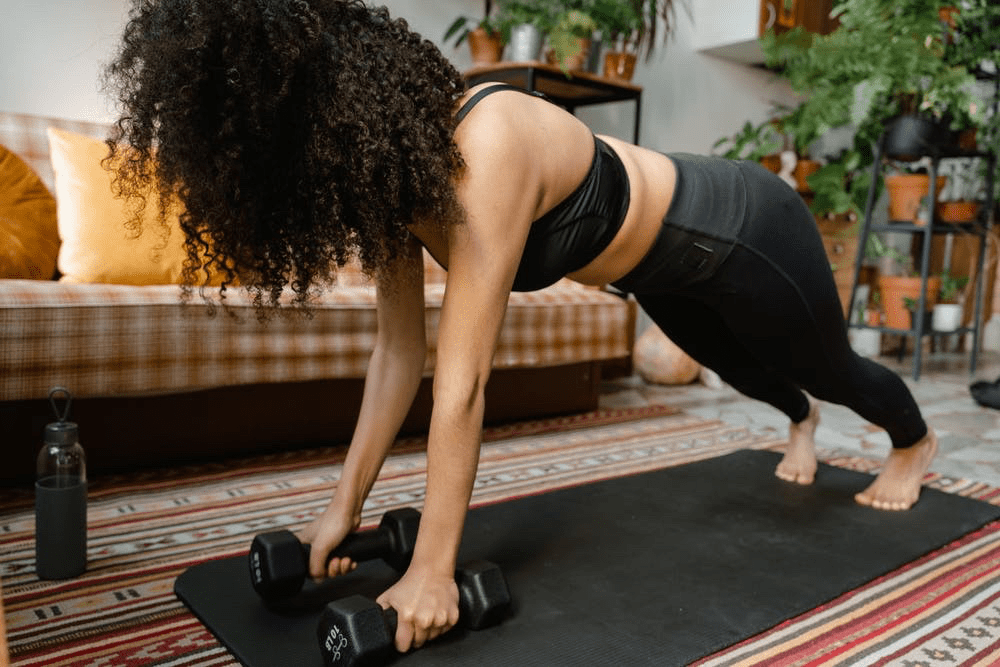 woman starting dumbbell plank row at home