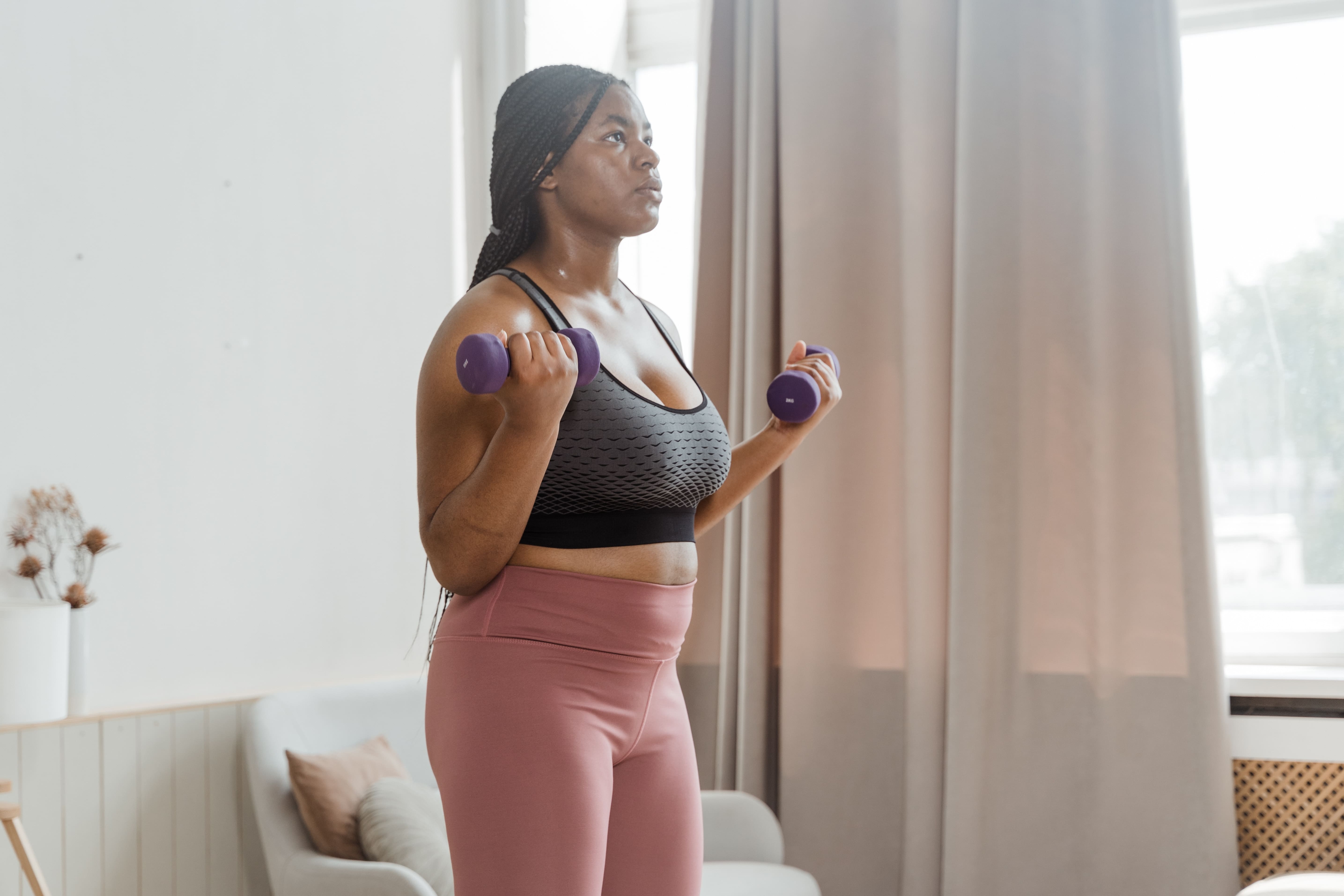 woman doing dumbbell bicep curls at home
